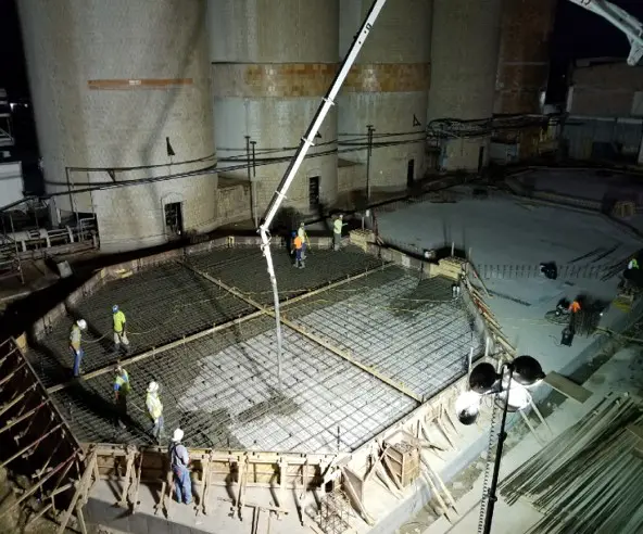 A group of people working on concrete in a building.